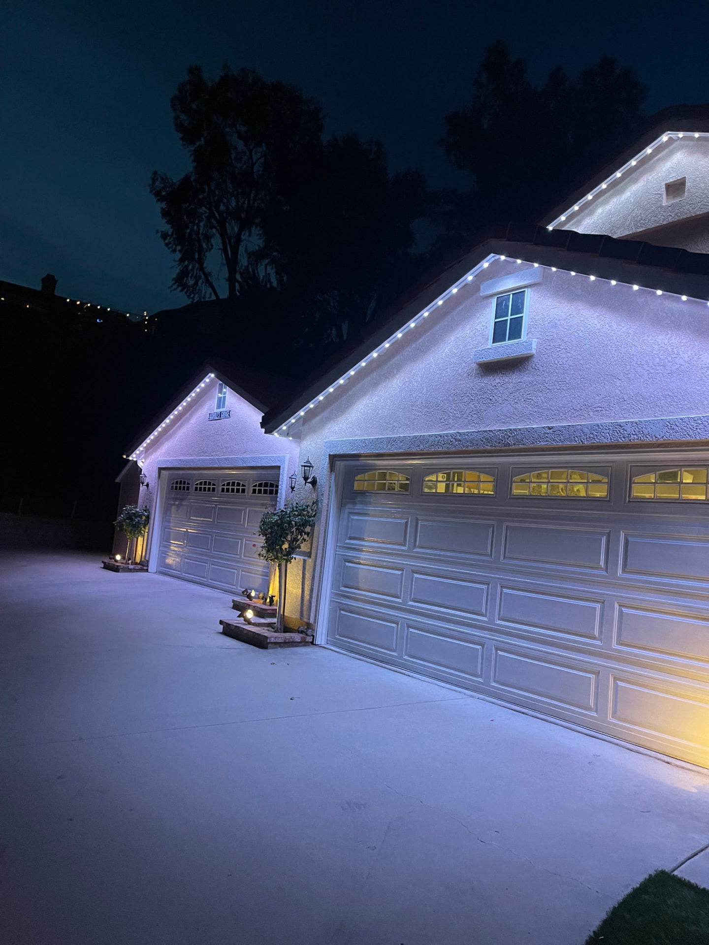 Garage gables outlined in crisp white permanent LED lighting at night