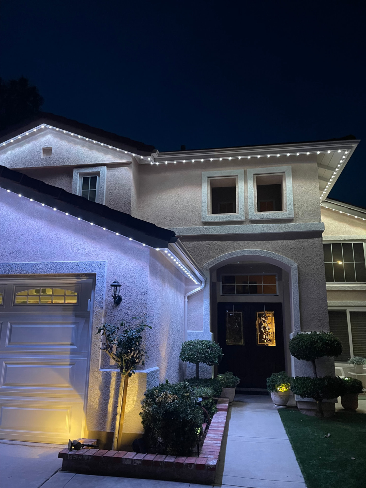 Two-story entry with crisp white permanent roofline lights